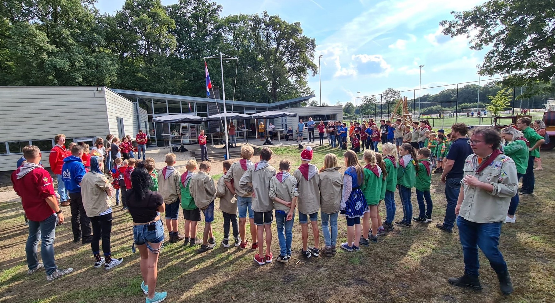 Heel de vereniging Scouting Petrus Donders die op het buitenterrein de openingsceremonie uitvoert